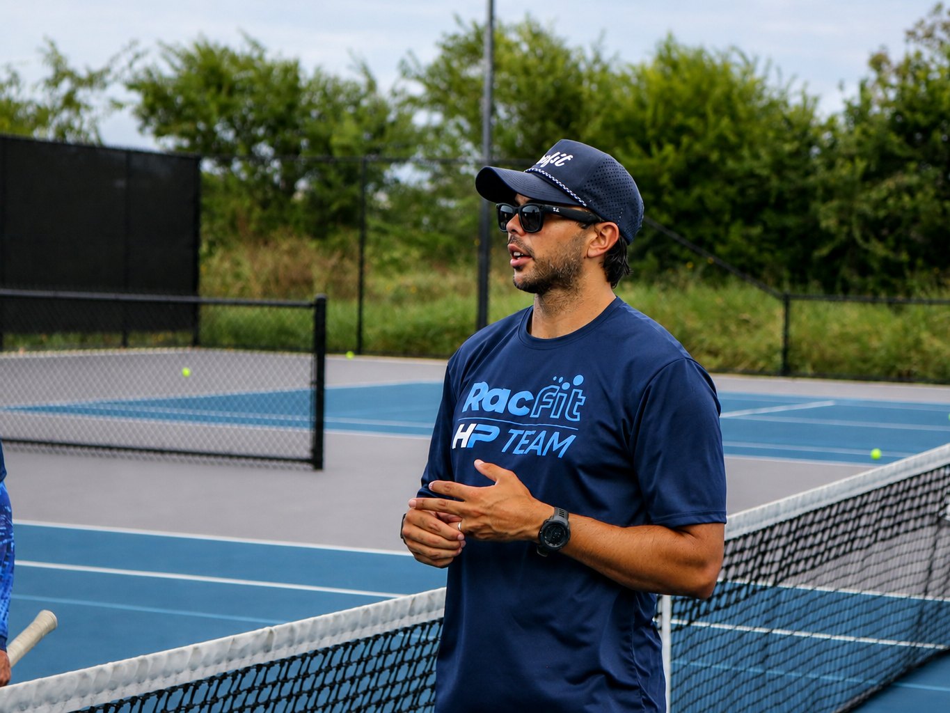 High Performance coach talking to players at the net at RacFit in Buda, Texas
