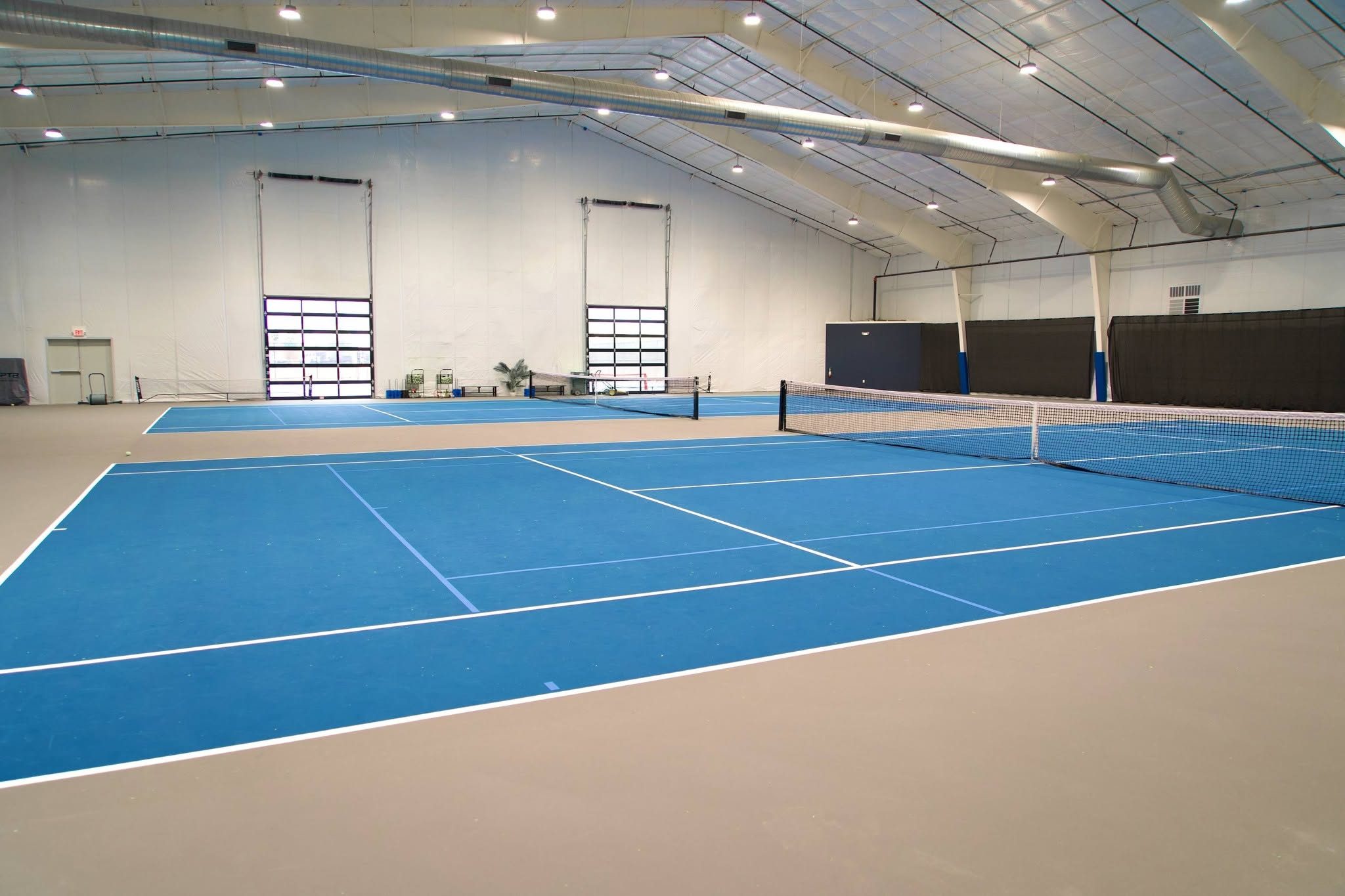 The two indoor climatized tennis courts at RacFit in Buda, Texas