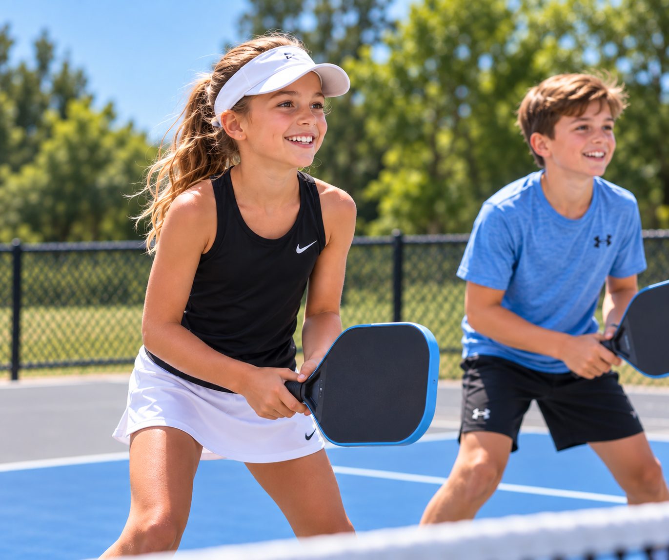 Two junior players in ready position at the net during a Junior Pickleball class at RacFit in Buda, Texas