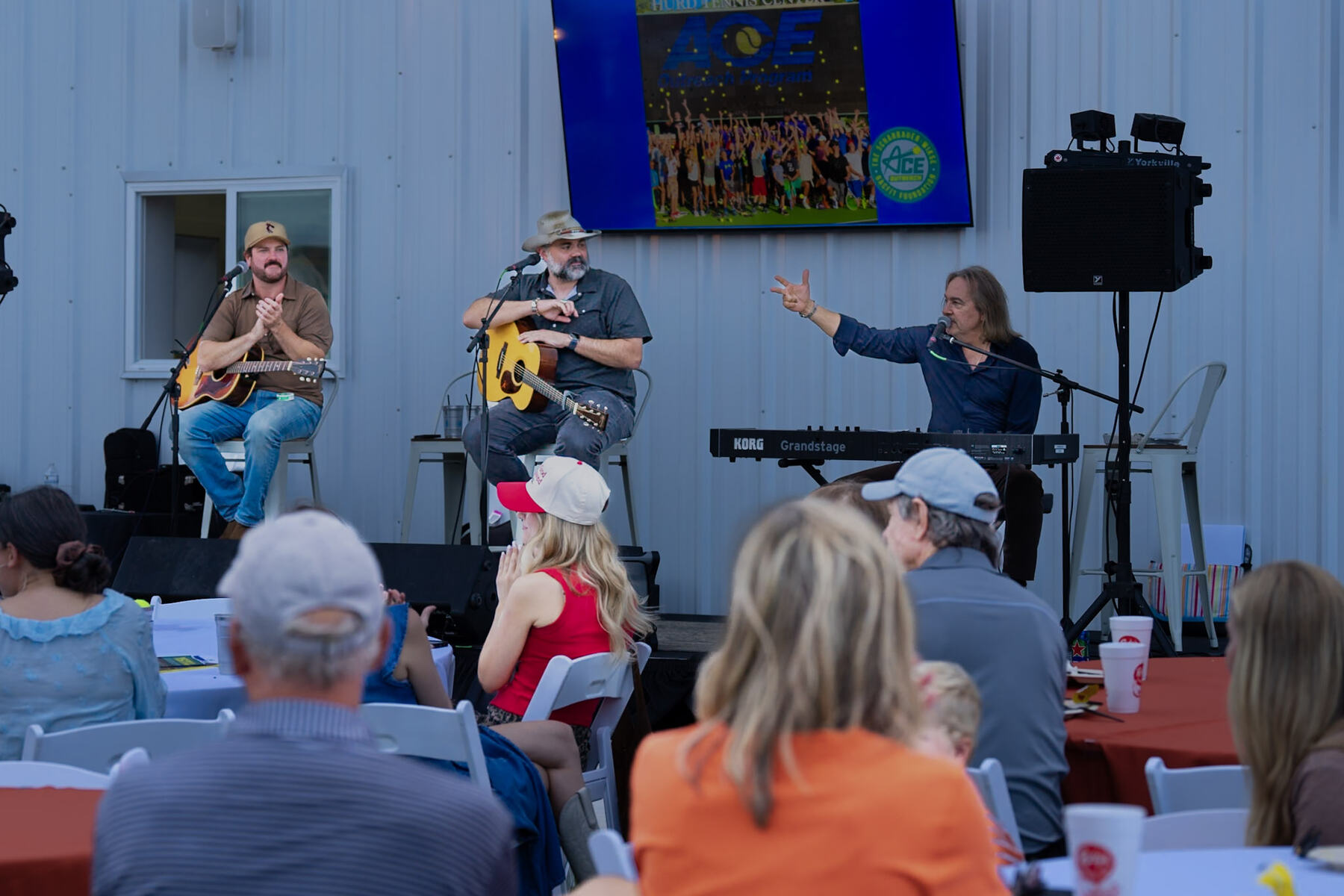 Crowd on the outdoor lawn event space at RacFit in Buda, Texas