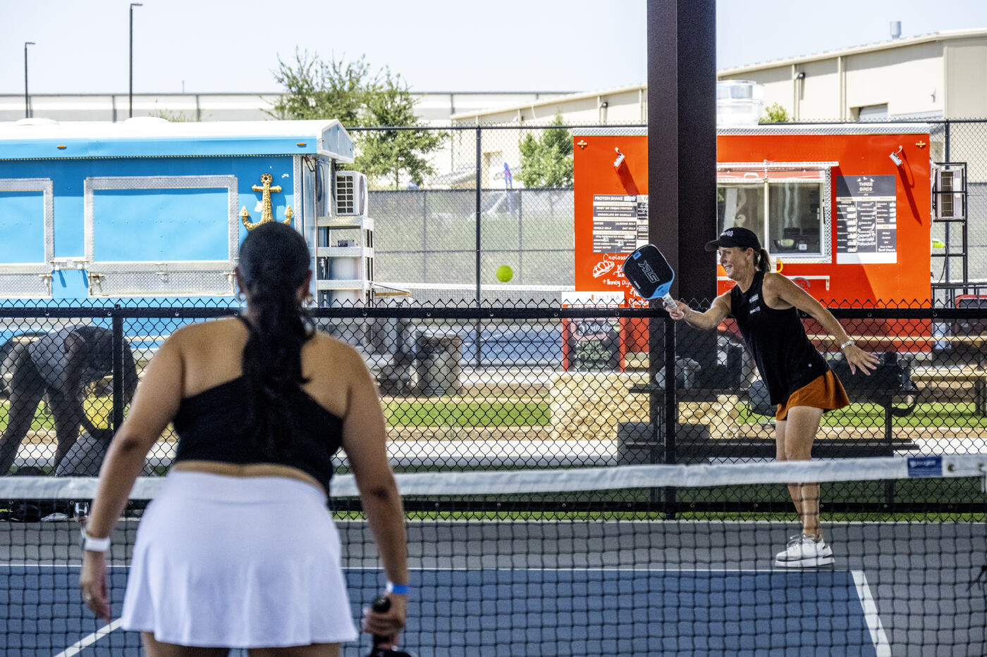 Pickleball rally on the outdoor courts at RacFit in Buda, Texas