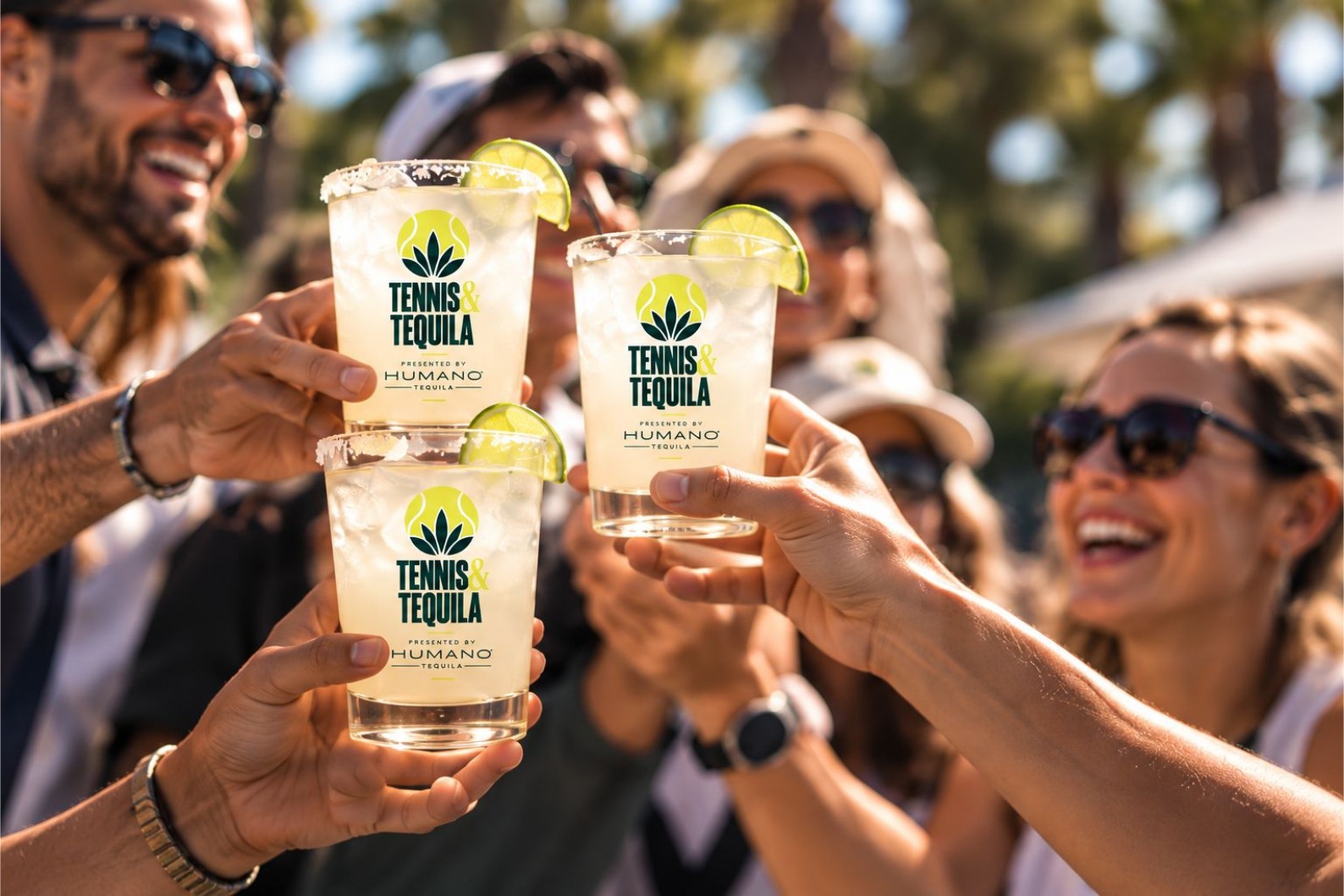 Guests raising branded Tennis & Tequila cocktails in a toast on the courts at RacFit in Buda, Texas