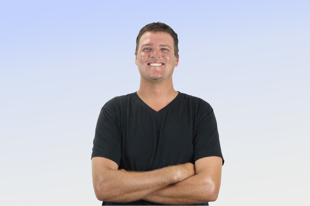 Smiling person in black shirt against gradient background.