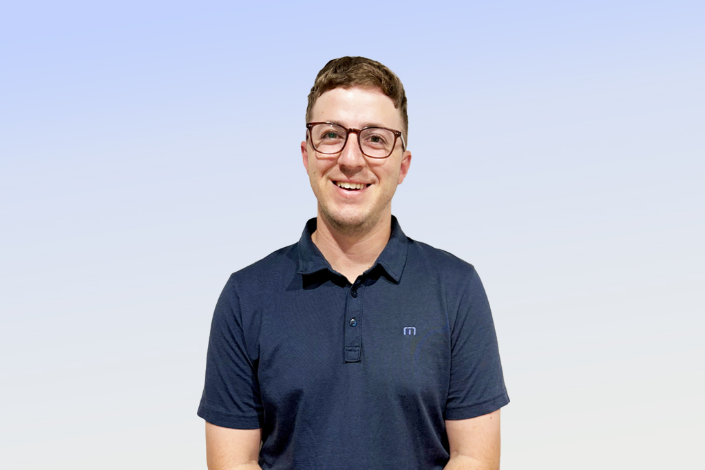 Smiling person in glasses and blue shirt