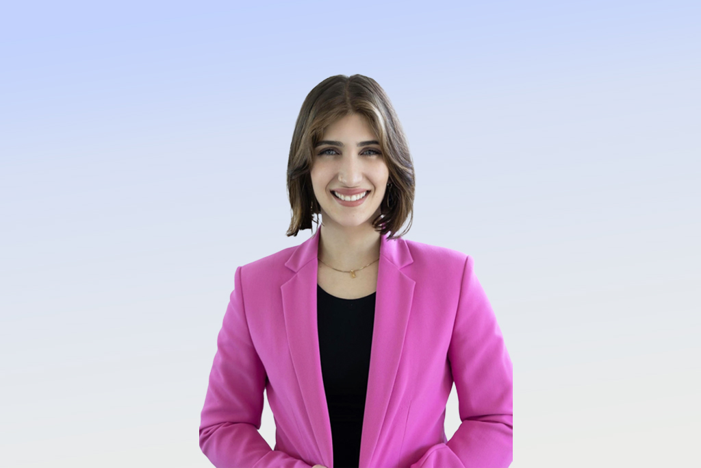 Woman in pink blazer smiling.
