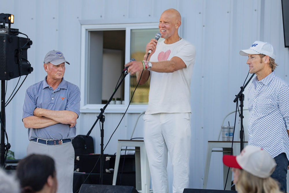 Man speaking into microphone at outdoor event