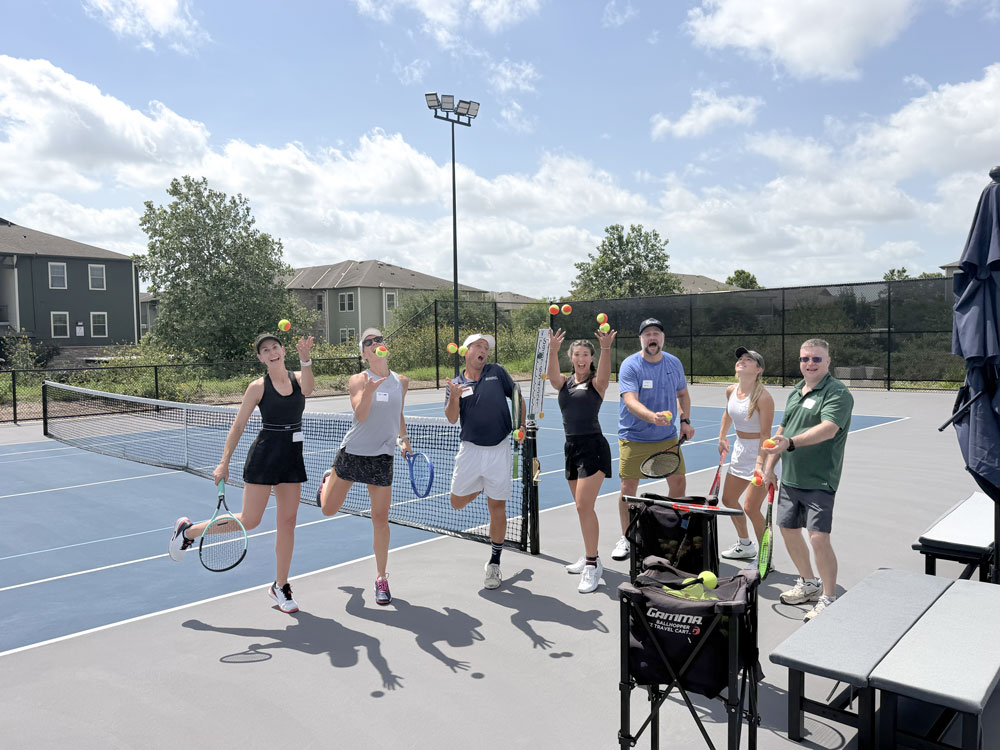Group playing tennis on sunny outdoor court